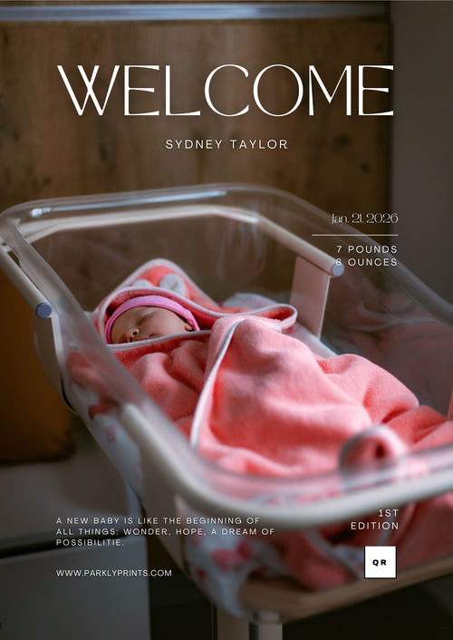 Newborn baby in a crib with pink blanket, welcome sign above, wooden background